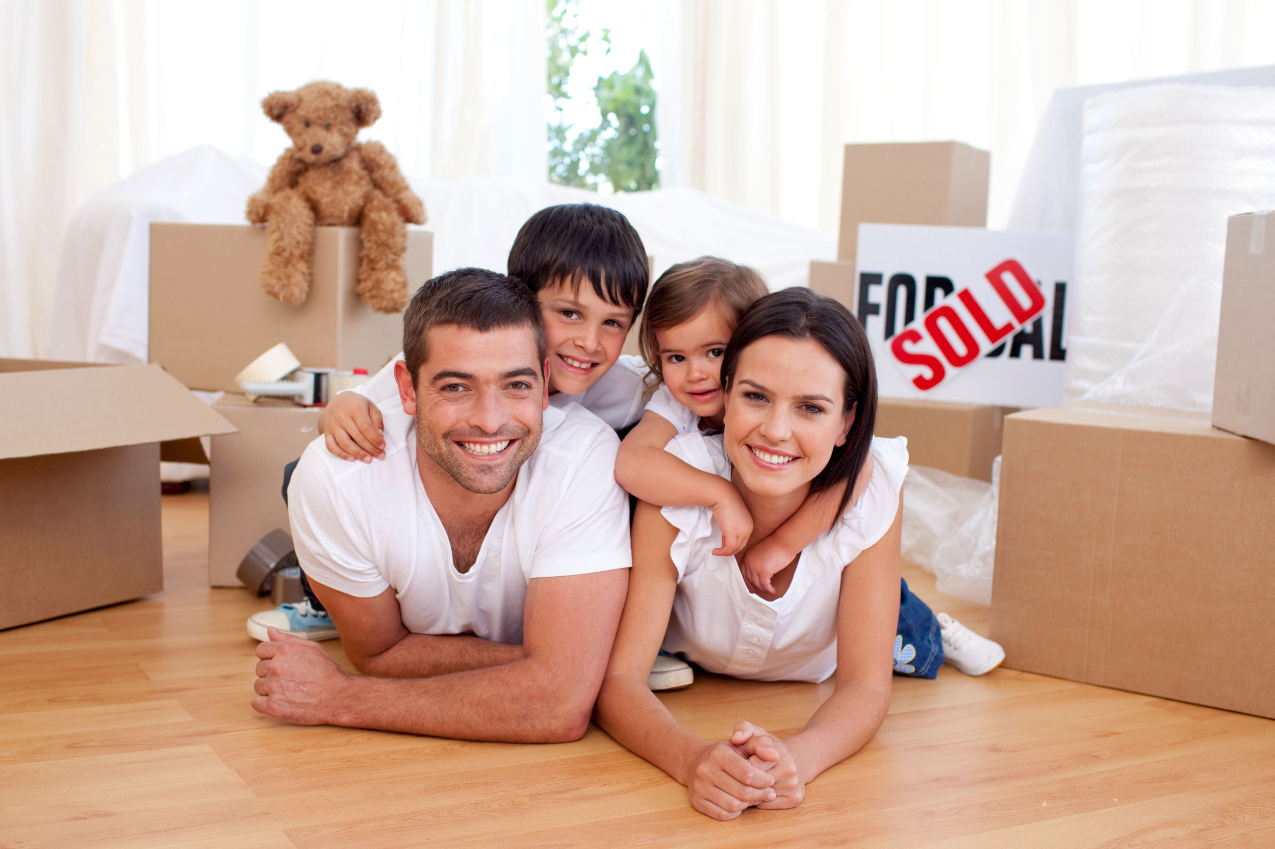 Young family smiling with moving boxes