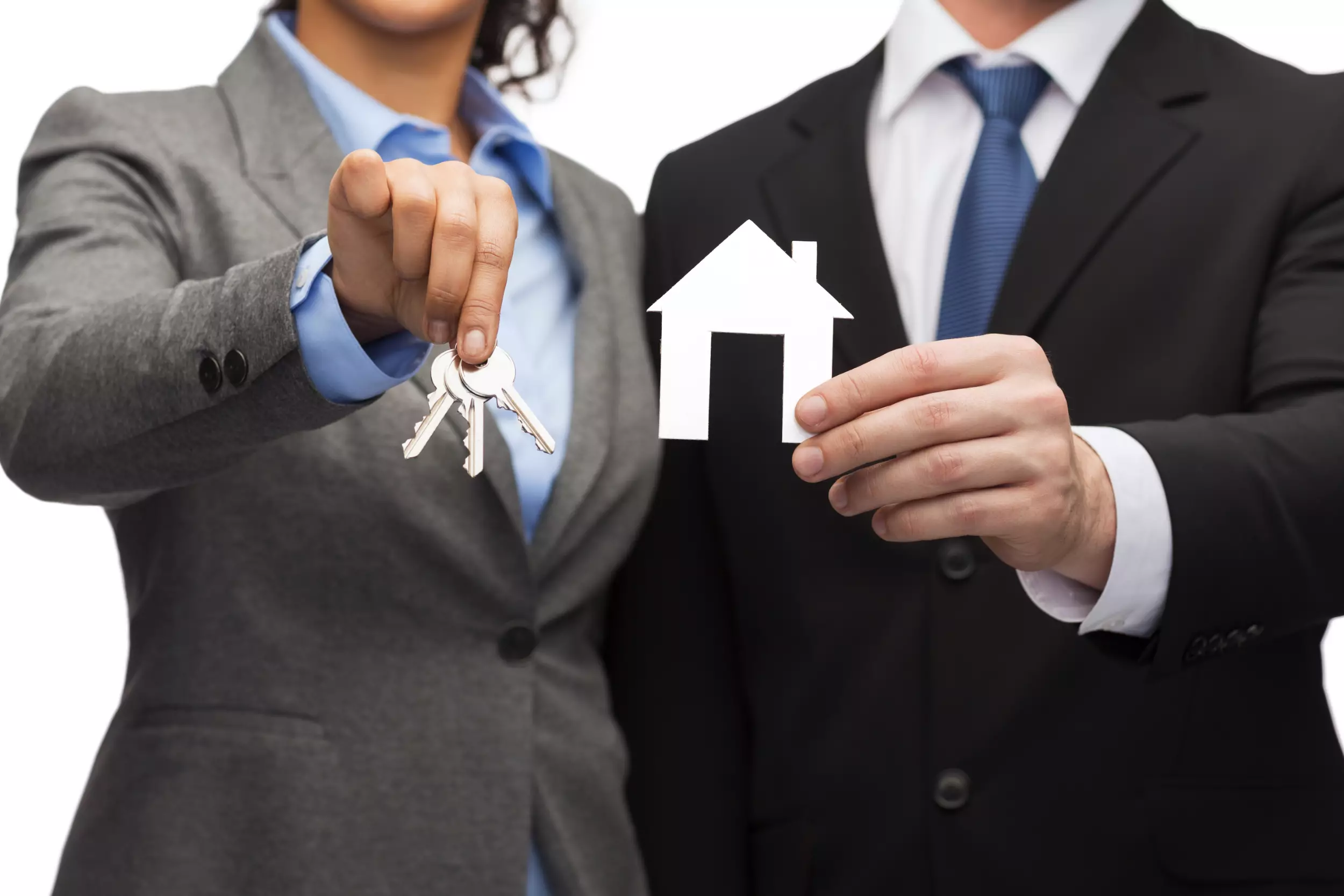 Realtors holding keys and a house cutout